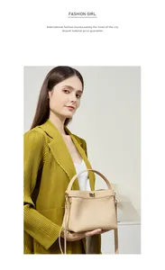 Close-up of beige litchi grain leather bucket bag featuring a metal turn-lock and top handle