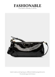 Detail of glossy black oil wax leather texture on a minimalist baguette shoulder bag