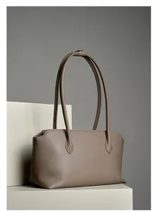 Dettaglio ravvicinato della trama in pelle martellata color talpa su borsa tote