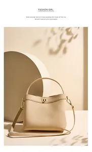 Detail of beige lychee leather bucket bag with gold twist lock and elegant shadows