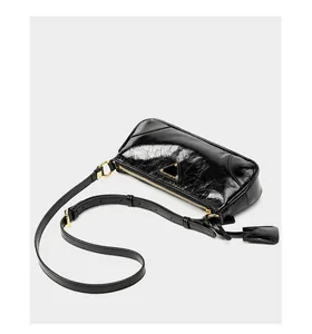 Detail of black oil wax leather shoulder bag with golden zipper and triangle hardware