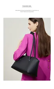Dettaglio borsa tote in pelle martellata nera indossata a spalla da una modella