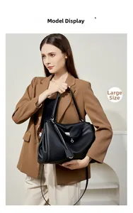 Grande borsa a mano in pelle nera con chiusura argentata indossata da modella