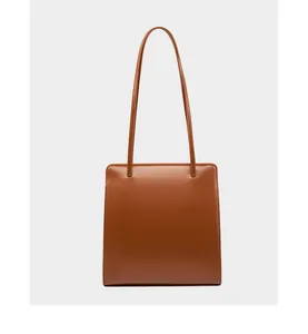 Détail du sac cabas en cuir caramel avec coutures élégantes et fines bretelles de qualité