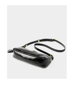 Detailed close-up of glossy black oil wax leather and gold metal buckle on baguette bag