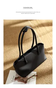 Borsa tote in pelle nera a grana litchi su tappeto beige con rivista di moda e occhiali