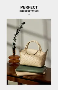 Close-up of cream woven leather handbag with dual handles on a wooden table setup