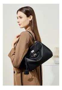 Dettaglio borsa tote in pelle nera con chiusura a rotazione argento e ciondolo