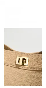 Detail of light beige lychee pattern leather handbag with polished gold rectangular twist lock