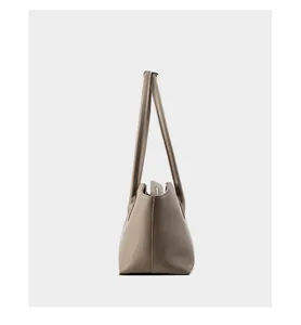 Vista dettagliata della borsa tote in pelle taupe grana con cuciture fini e spalline lunghe