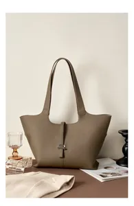 Dettaglio della pelle martellata e della chiusura in metallo su borsa tote kaki