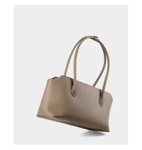 Dettaglio di una borsa tote in pelle color talpa con trama litchi e spalline sottili
