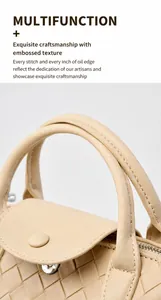Detail shot of beige woven leather handbag with intricate craftsmanship and metal zipper