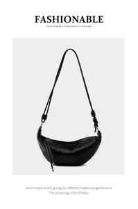 Close-up of black leather croissant bag showing quilted grain texture and knot detail