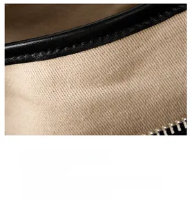 Detail of premium black leather croissant bag showing silver zipper and textile lining
