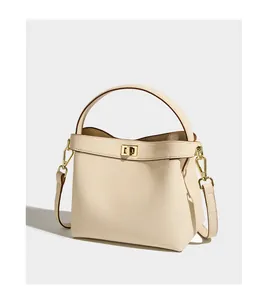 Detail of lychee pattern leather texture and golden metal twist lock on bucket bag