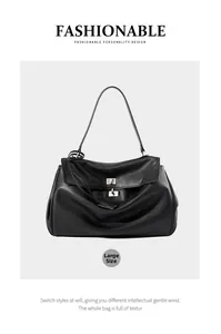 Dettaglio della grande borsa tote in pelle nera con chiusura a scatto e trama naturale