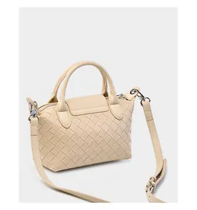 Detail of woven cream leather bag showing silver hardware and crossbody strap