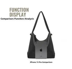 Detail view of large black leather hobo bag with silver rivets compared with a tablet