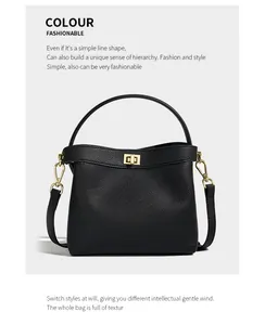 Close-up of black pebbled leather texture and polished gold metal buckle on a bucket bag