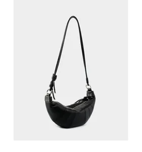 Detail of black quilted lambskin leather croissant bag with knotted strap and zip closure