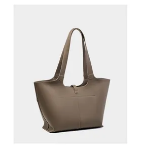 Dettaglio della texture in pelle granata e cuciture fini su una borsa tote