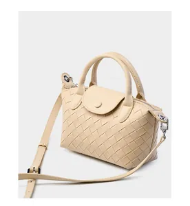 Detail of cream woven leather handbag featuring precise cross-weave texture and silver hardware