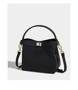 Close-up of black lychee grain leather handbag with gold twist lock and sturdy handle