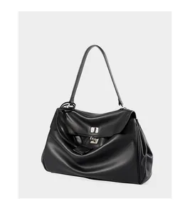 Dettaglio di una grande borsa tote in pelle nera con chiusura a rotazione in argento