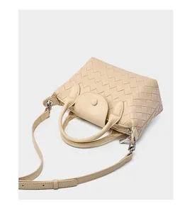 Detail of beige woven leather tote bag with zip closure and silver metal hardware
