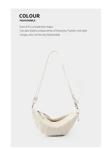 Detail of cream croissant bag with vertical stitching and elegant side knot design