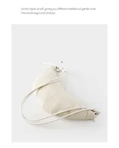Detailed view of cream leather croissant bag with soft quilted texture and minimalist strap