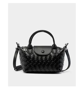 Detail of black woven leather handbag with silver hardware and adjustable shoulder strap