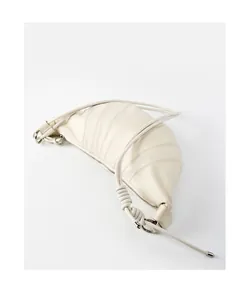 Detail of creamy white leather croissant bag with knotted strap and silver ring hardware
