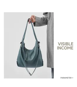 Detailed macro view of dark cyan leather shoulder bag with silver metal studs and texture