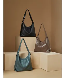 Detail view of large leather hobo shoulder bags in black, dark brown and grey-blue