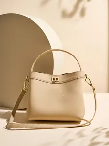 Elegant beige pebbled leather bucket bag with gold twist lock and dual strap design