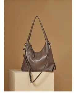 Detail view of large brown leather hobo bag with pebble texture and silver hardware