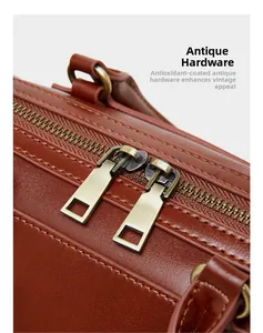 Detail of vintage bronze dual zippers on premium brown leather Boston handbag texture