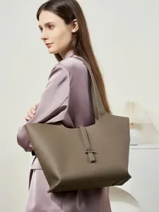 Grande borsa tote in pelle tortora con fibbia in metallo indossata da una modella
