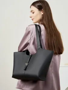 Grande borsa tote in pelle nera con trama lychee e fibbia argento portata a spalla