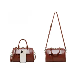 Brown leather Boston bag size comparison with iPhone 15 Pro and crossbody strap view