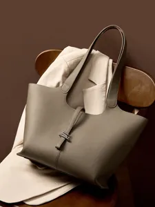 Grande borsa tote in pelle martellata grigio elefante da donna su una sedia
