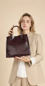 Λεπτομέρεια της μπορντό δερμάτινης τσάντας με κάθετη ραφή και μεταλλικά στηρίγματα