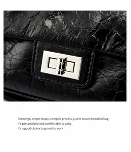 Détail du cuir ciré noir et du fermoir rectangulaire argenté tournant sur le sac