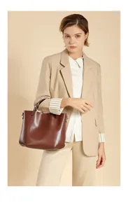 Dettagli di una borsa tote in pelle marrone scuro con ganci e interno spazioso
