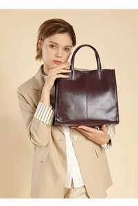 Deep burgundy leather tote bag with vertical stitching shown in a professional studio shot