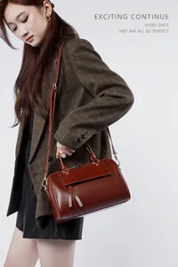 Brown leather Boston bag shown styled with a plaid blazer for a vintage commuter look