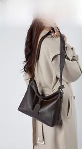 Model display of a large dark brown genuine leather hobo bag with a wide shoulder strap
