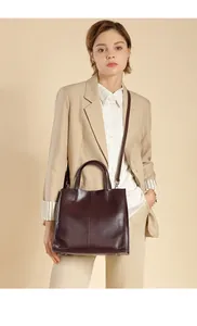 Deep burgundy leather tote bag styled with a beige blazer for a professional look